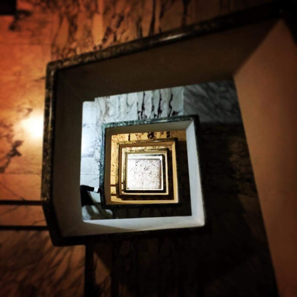 Looking down a circular marble stairwell